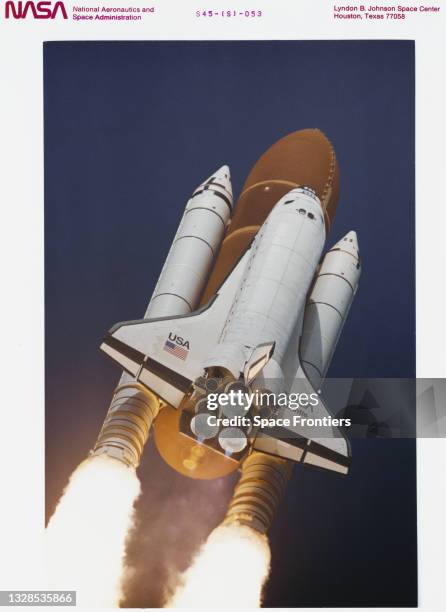 Low angle view of the space shuttle Atlantis as it soars off the launchpad and heads towards Earth Orbit with a crew of seven and the Atmospheric...