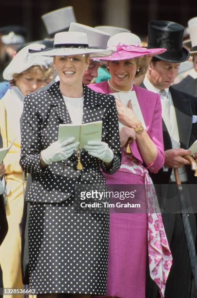 British Royals Sarah, Duchess of York, wearing a dark blue outfit with white polka dots and white wide brim hat with a dark blue band, and Diana,...