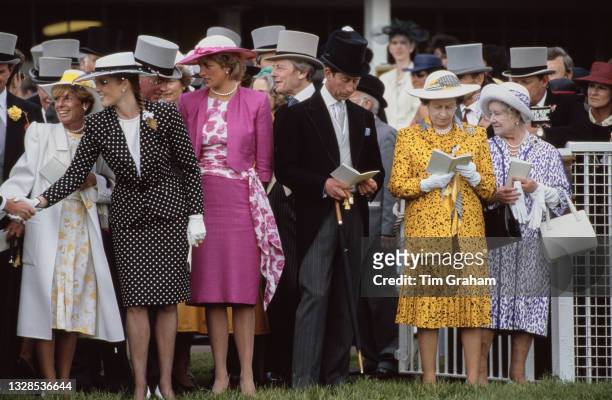 British Royals Sarah, Duchess of York, wearing a dark blue outfit with white polka dots and white wide brim hat with a dark blue band, and Diana,...