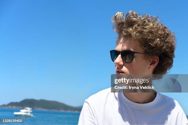 young man or teenager in a white t-shirt  travels and discovers the beautiful mediterranean landscape in europe. - boat top view stock pictures, royalty-free photos & images