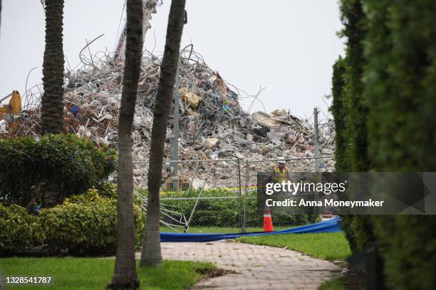 Excavators dig through the pile of debris from the collapsed 12-story Champlain Towers South condo building following a severe thunderstorm on July...