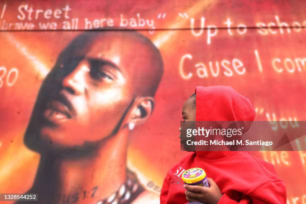 Exodus Simmons son of DMX, looks at a mural of his father the late rapper Earl "DMX" Simmons at the Calcagno Houses on July 13, 2021 in Yonkers, New...