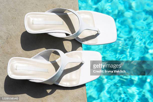 fashion white shoes flip-flop and swimming pool with turquoise water as sunny summer stylish background. - sandales photos et images de collection