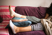Injured Hispanic Woman Elevating Bandaged Sprained Angle on the Sofa