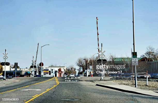 railroad crossing with signs for caution - yolo county stockfoto's en -beelden