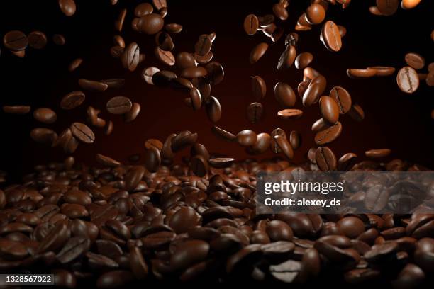 fallende geröstete kaffeebohnen auf braunem hintergrund - geröstete kaffeebohne stock-fotos und bilder