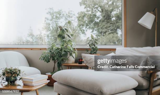 stylish home interior with a large window and modern furniture - coffee table stock pictures, royalty-free photos & images