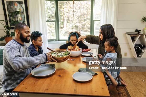 high angle view of family having meal together - cena-familiar fotografías e imágenes de stock