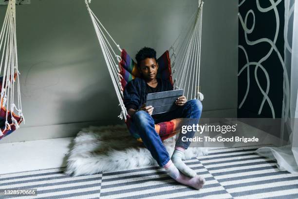 teenage girl using digital tablet while relaxing in cozy chair at home - girl with blue hair stock pictures, royalty-free photos & images