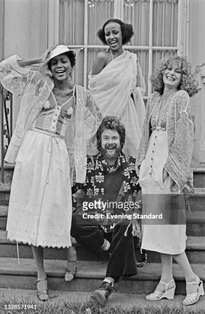 Scottish fashion designer Bill Gibb with three models, UK, 30th October 1974.