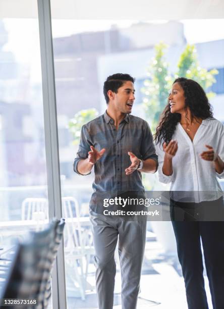 businessman and businesswoman walking and talking. - side by side 個照片及圖片檔