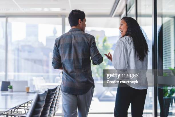 rear view of businessman and businesswoman walking and talking. - 2 people back asian imagens e fotografias de stock