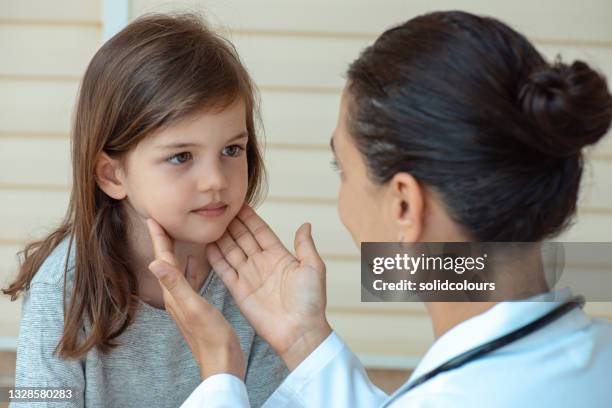 doctor controls tonsil's of cute girl. - throat stock pictures, royalty-free photos & images