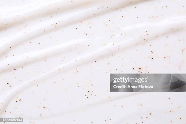 texture of white body scrub with exfoliating particles. flat lay style - kokosnussöl stock-fotos und bilder