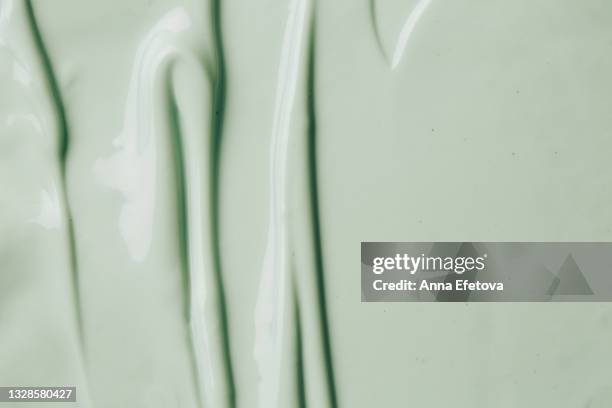 background made of textured smears of green cream. flat lay style - glace texture imagens e fotografias de stock