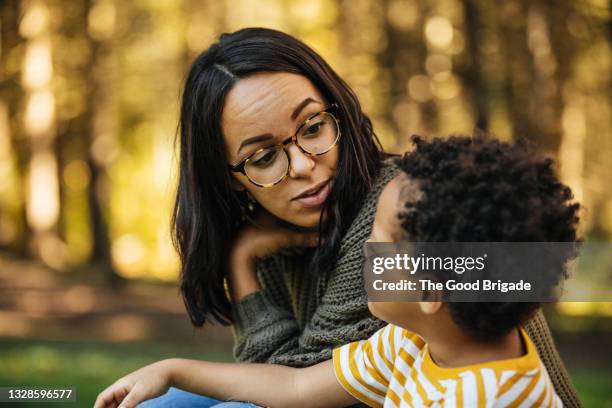 mother talking to son outdoors - parents - fotografias e filmes do acervo