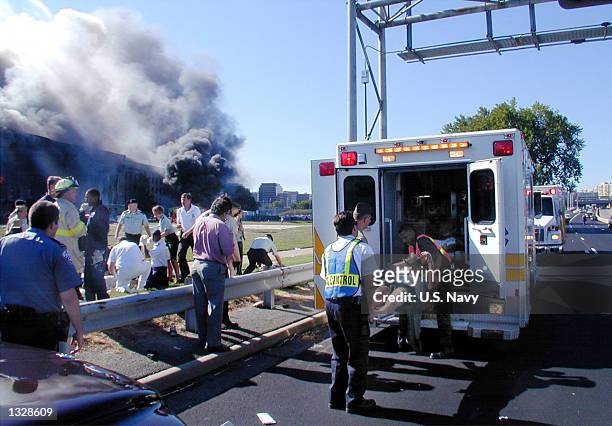 Medical personnel load a wounded Pentagon worker into an ambulance at the first medical triage area set up outside the Pentagon September 11, 2001...
