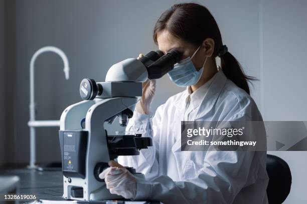 顕微鏡を使った女性医師 - microscope ストックフォトと画像
