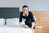 Housekeeper Making A Bed In Hotel Room