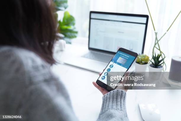 woman check credit card balance statement via internet banking on mobile phone - electronic banking stock-fotos und bilder