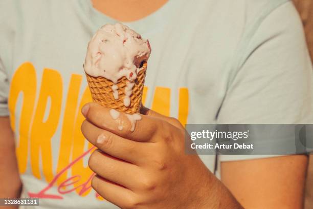 kid holding ice cream cone melting in hot summer. - freezing hands stockfoto's en -beelden
