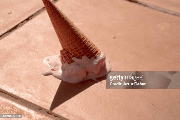 misfortune picture of ice cream cone fallen in the street floor. - al revés posición descriptiva fotografías e imágenes de stock