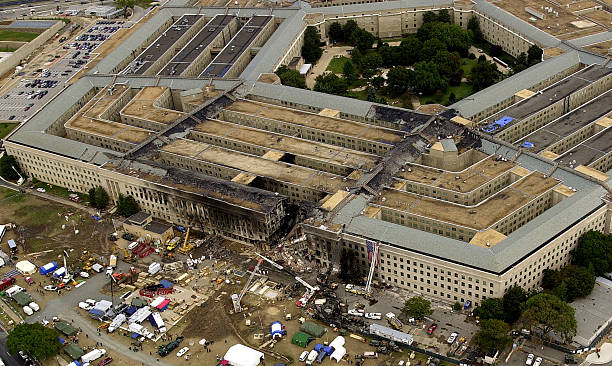 Agents, fire fighters, rescue workers and engineers work at the Pentagon crash site September 14, 2001 where a hijacked American Airlines flight...