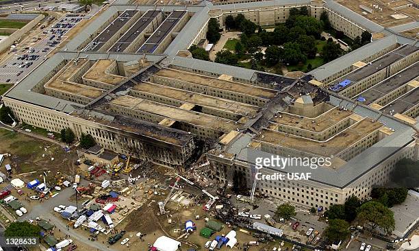 Agents, fire fighters, rescue workers and engineers work at the Pentagon crash site September 14, 2001 where a hijacked American Airlines flight...