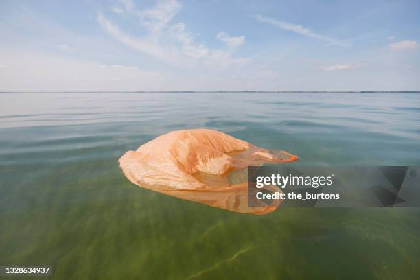 plastic bag floating in the sea - garbage bag stock pictures, royalty-free photos & images