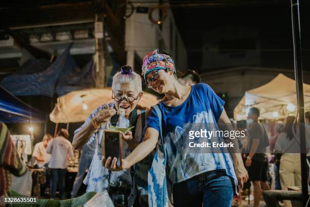humor active senior women show her eating street local food in live streaming at night market- stock photo - the weekend in news around the world stock pictures, royalty-free photos & images