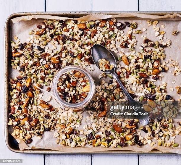 tray of granola on white, wooden background - savory stock-fotos und bilder