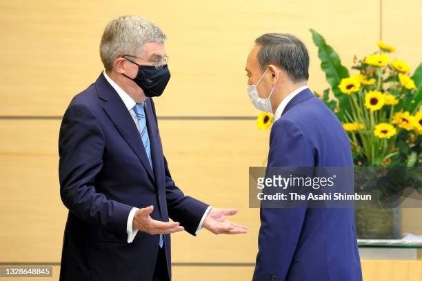 Japanese Prime Minister Yoshihide Suga and IOC President Thomas Bach greet prior to their meeting at the prime minister's office on July 14, 2021 in...