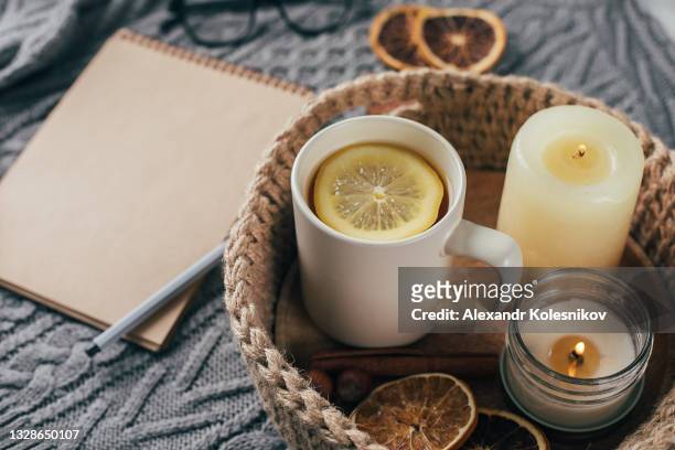 cup of tea with lemon in jute knitted baskets, candles, dry orange and empty notebook for text. hygge concept. cozy mood christmas. - gift hamper imagens e fotografias de stock