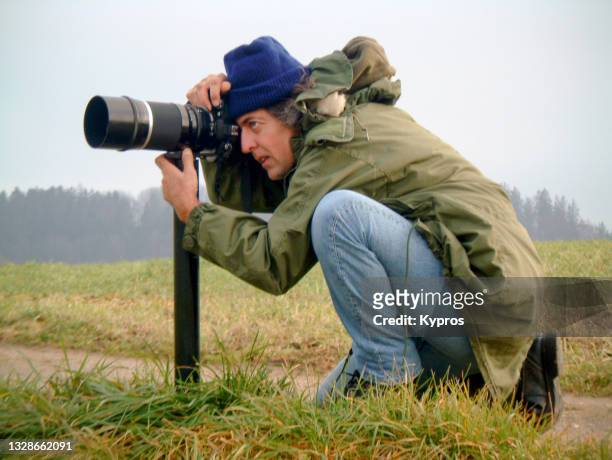 photographer with camera and 1000mm telephoto mirror lens - photojournalist stock pictures, royalty-free photos & images