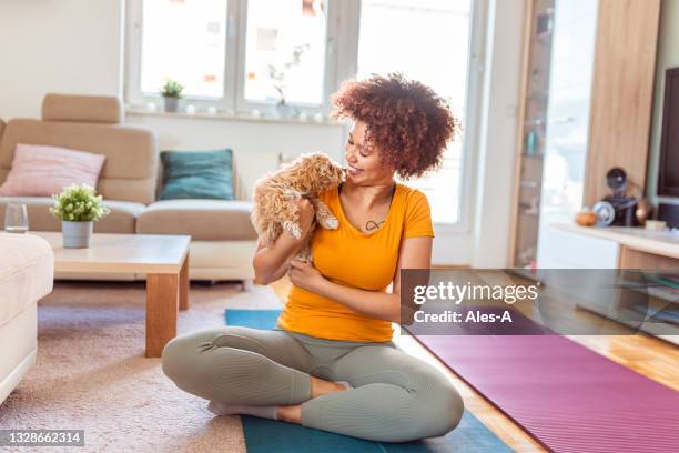 young woman cuddling her puppy at home - black hairy women bildbanksfoton och bilder