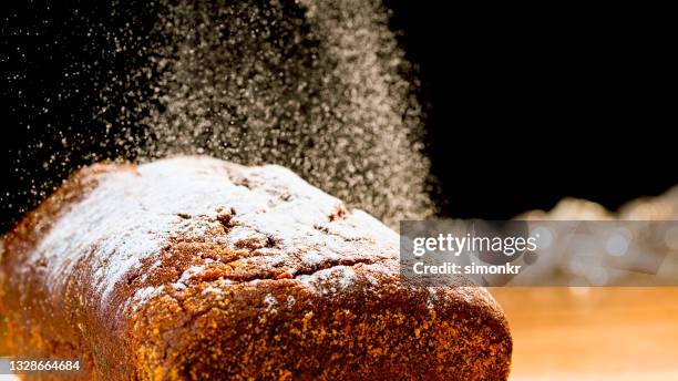 puderzucker auf kuchen streuen - puderzucker stock-fotos und bilder