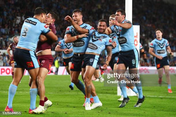 Api Koroisau of the Blues celebrates with team mates after scoring a try as Latrell Mitchell of the Blues wrestles with Dane Gagai of the Maroons...