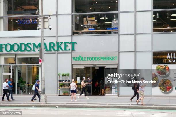 Pedestrians walk past a Whole Foods Market on July 13, 2021 in New York City.