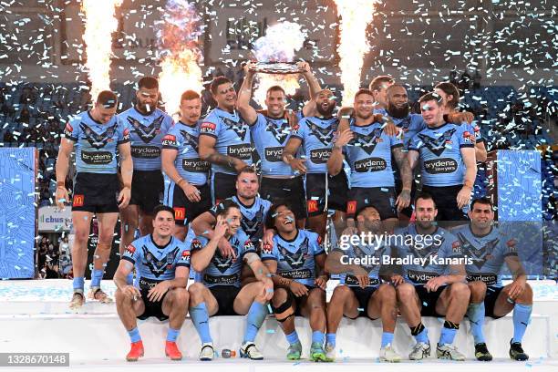 James Tedesco of the Blues holds aloft the Origin trophy and celebrates with team mates after winning the series 2-1 after game three of the 2021...