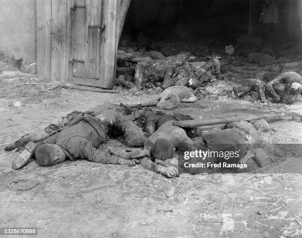 The bodies of prisoners massacred by the local Volkssturm, Hitlerjugend and SS Schutzstaffel guards lay outside the doorway of the burned out barn on...