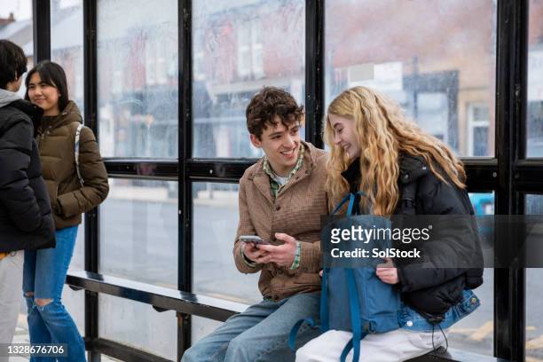 waiting for the bus together - bus stop uk stock pictures, royalty-free photos & images