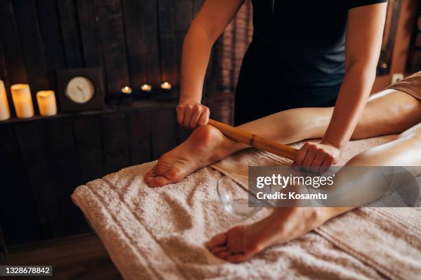 masseuse using the bamboo roller, during massage session at the luxury beauty spa center - bamboo stock pictures, royalty-free photos & images