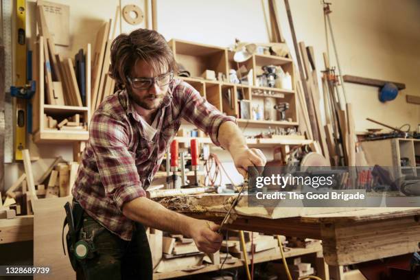 carpenter shaving wood with drawknife at workshop - carpenter - fotografias e filmes do acervo