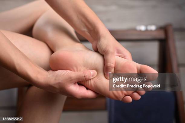 woman in pain massaging her feet - pied photos et images de collection