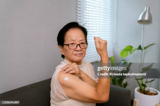 une femme âgée asiatique souriant après avoir reçu le vaccin contre la covid-19. - asian woman beauty shot photos et images de collection