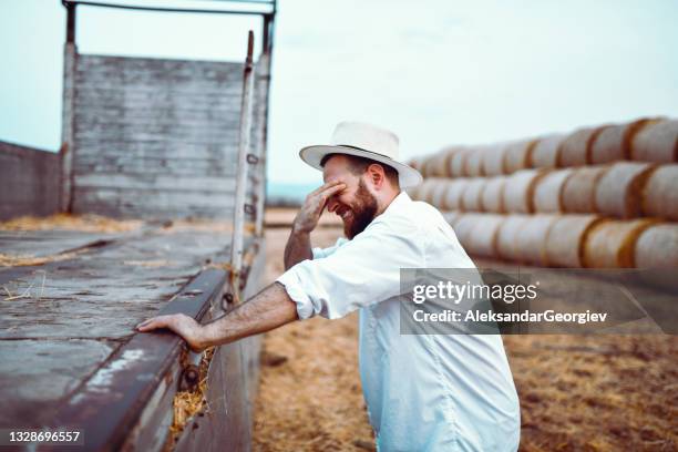 stressed farmer can't find way to load hay bales on transport truck - worried farmer stock pictures, royalty-free photos & images