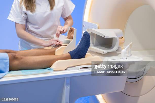 technicians preparing female patient for leg mri scan - foot mri stock pictures, royalty-free photos & images