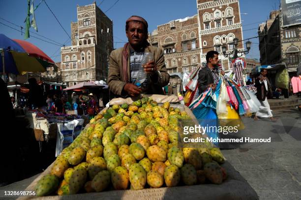 Yemeni vendor who sells prickly pear pushes his wheelbarrow seeking for customers at a market amid unprecedented economic crisis, low Rial value and...