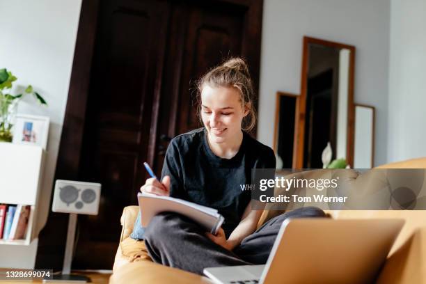 teenage girl taking notes during zoom class - só uma menina adolescente imagens e fotografias de stock