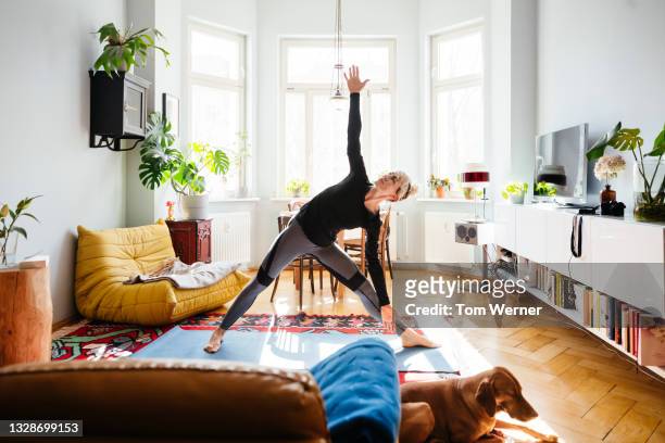 single mom stretching doing yoga at home - yoga foto e immagini stock